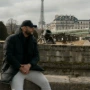 a man sitting on a wall in front of the eiffel tower